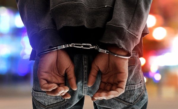 a person hands cuffed behind their back