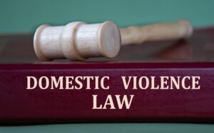 A gavel rests on a book about domestic violence law that addresses the question: What is considered domestic violence?